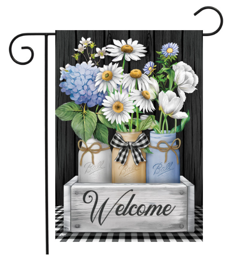 Decorative garden flag with flowers in jars and a 'Welcome' sign on a black and white checkered background.