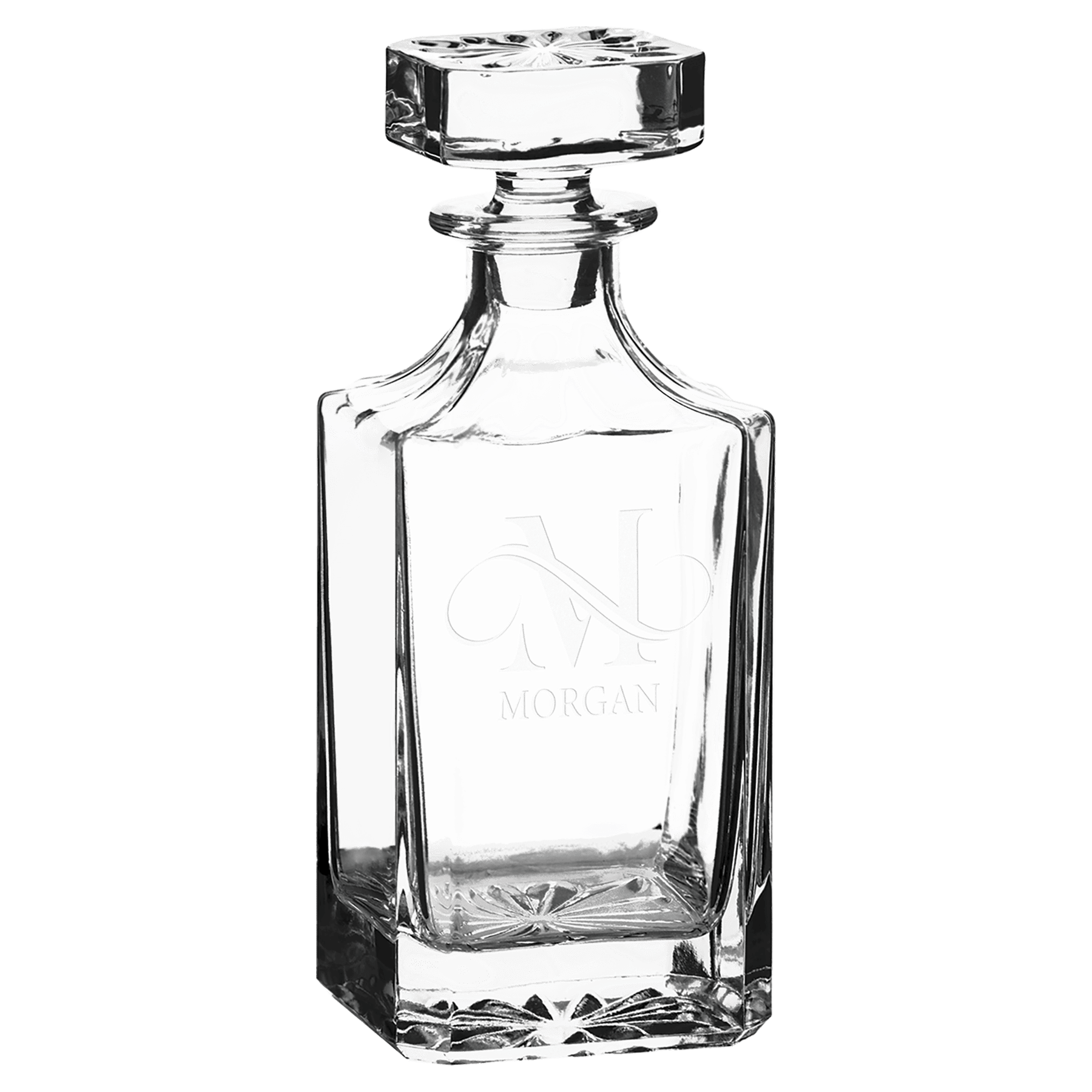 Clear glass decanter with engraved design on a green background