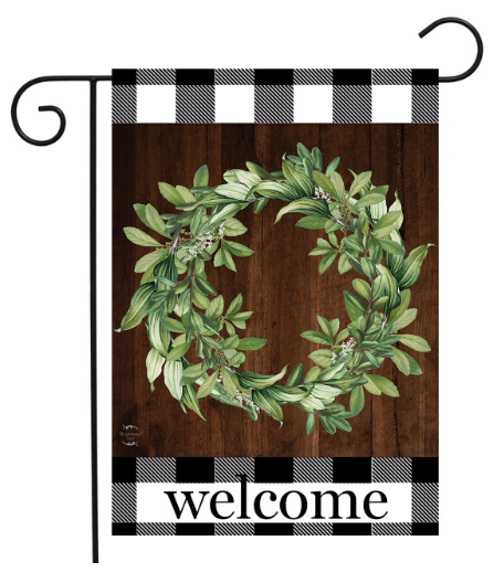 Decorative garden flag with a green wreath and 'welcome' text on a wooden background.
