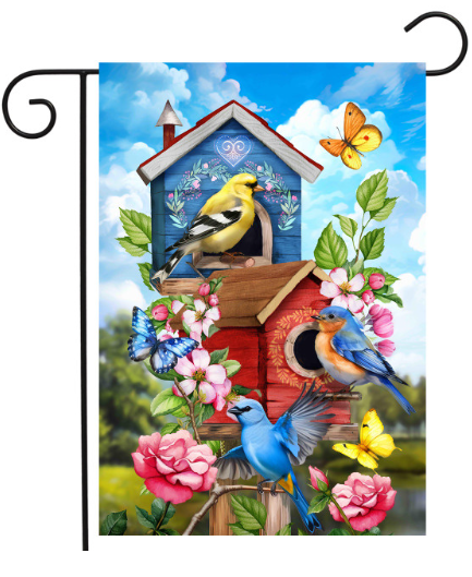 Decorative garden flag with birds, birdhouse, and flowers on a blue sky background.