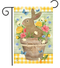 Decorative garden flag with a bunny in a basket surrounded by flowers and butterflies on a yellow and white checkered background.