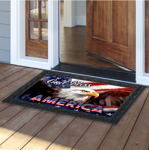 Decorative doormat with an eagle and 'God Bless America' text on a wooden floor.