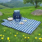 Blue and white checkered picnic blanket with a cooler bag on a grassy hillside.