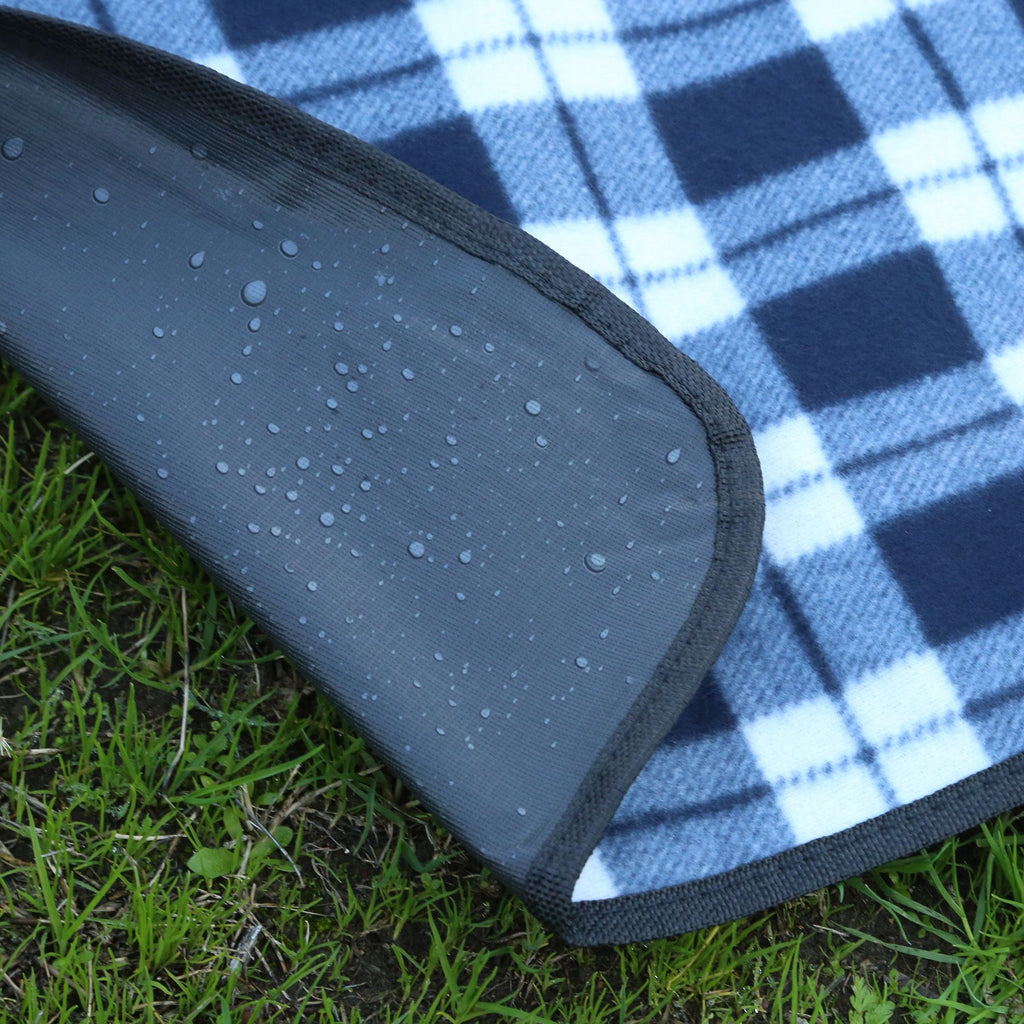 Blue and white checkered picnic blanket with a black border on grass