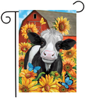 Decorative flag with a cow and sunflowers in front of a red barn.