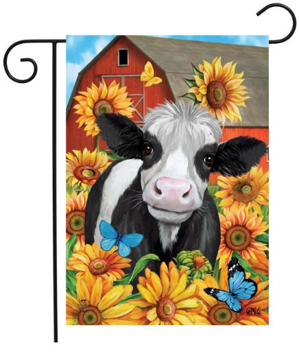Decorative flag with a cow and sunflowers in front of a red barn.