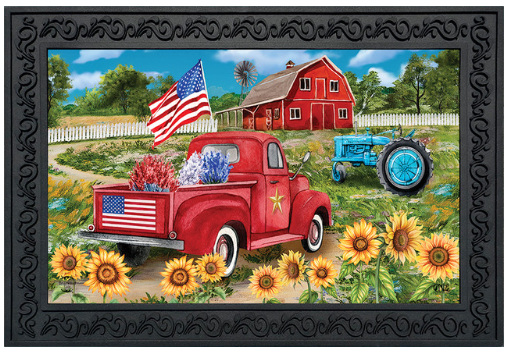 Red truck with American flag, barn, and tractor in a scenic setting with sunflowers.
