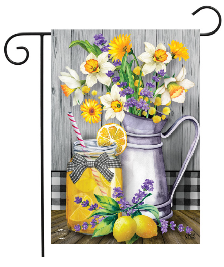 Decorative garden flag with flowers, lemons, and a pitcher on a wooden background