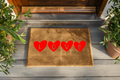 Doormat with red heart-shaped letters spelling 'LOVE' on a wooden floor.