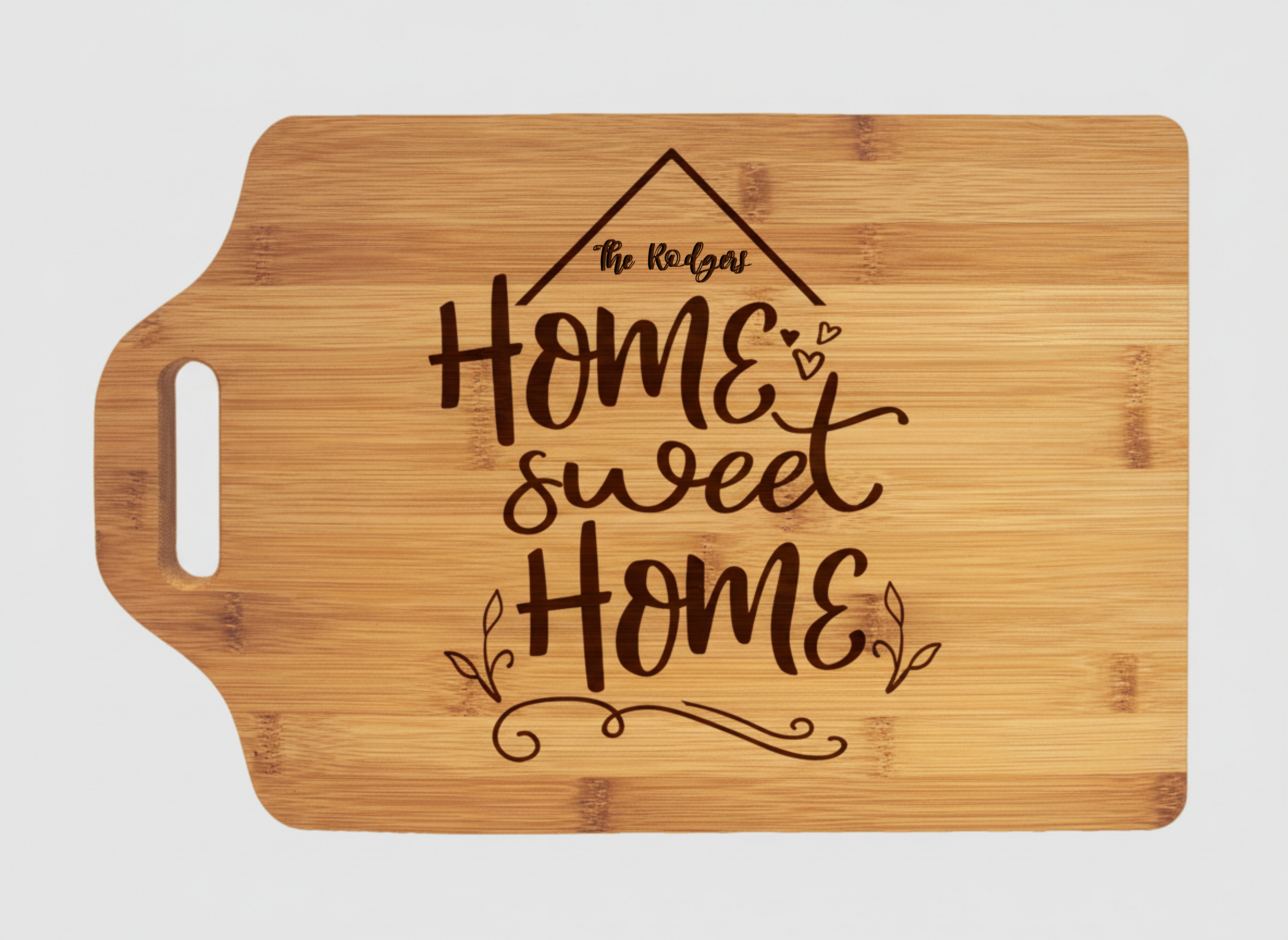 Bamboo cutting board with handle engraved with “Home Sweet Home” and a rooftop design, featuring a customizable family name inside the roof area.
