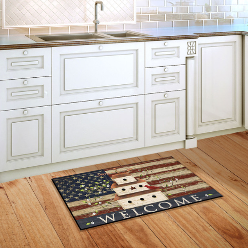 Kitchen with a decorative doormat featuring an American flag design on a wooden floor.