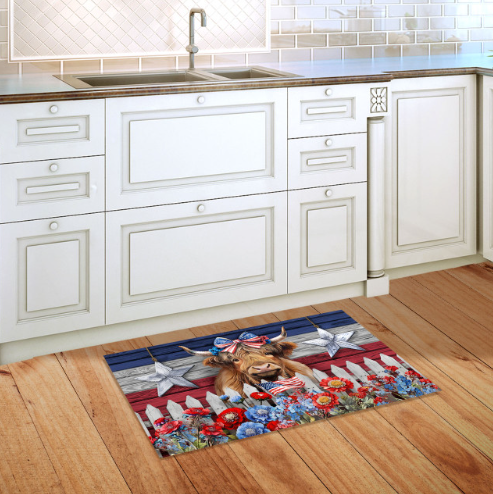 Decorative doormat with a cow design on a wooden floor in a kitchen.