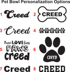 A digital graphic showing eight different pet bowl personalization options labeled 1 through 8. The options include various stylized and block-letter variations of the name 'Creed' in black, white, and red, alongside a black paw print design with 'CREED' inside the pad.