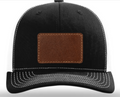 Black cap with a brown leather patch on a white background