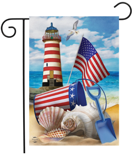 Decorative flag with a lighthouse, American flag, sand bucket, shovel, and shells on a beach background.