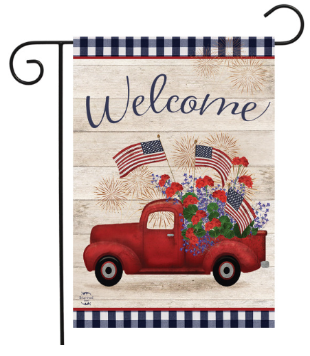 Decorative garden flag with a red truck, American flags, and fireworks on a wooden background.