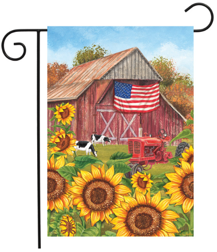 Decorative flag with a barn, American flag, tractor, and sunflowers.
