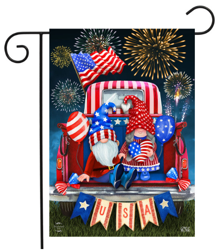 Decorative flag with gnomes in a truck, American flags, and fireworks on a dark blue background.