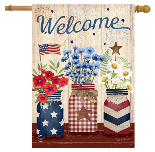 Decorative flag with 'Welcome' text, flowers, and American flags on a wooden background.