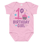 Pink baby onesie with '1st Birthday Girl' text and birthday-themed graphics on a white background