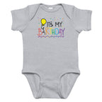 Gray baby onesie with colorful 'It's My Birthday' text and balloon design on a white background