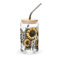 Glass tumbler with sunflower design, wooden lid, and metal straw on a white background