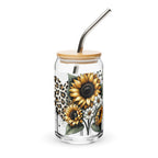 Glass tumbler with sunflower design, wooden lid, and metal straw on a white background