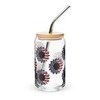 Clear glass tumbler with floral design, wooden lid, and metal straw on a white background
