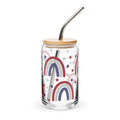 Glass tumbler with rainbow design, wooden lid, and metal straw on a white background