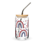 Glass tumbler with rainbow design, wooden lid, and metal straw on a white background