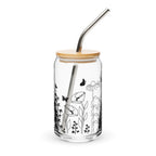 Glass tumbler with bamboo lid and metal straw featuring black floral and butterfly design on a white background