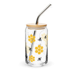 Glass tumbler with bamboo lid and metal straw featuring honeycomb and bee design on a white background