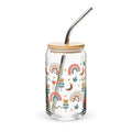 Glass tumbler with a bamboo lid and metal straw featuring colorful patterns on a white background.