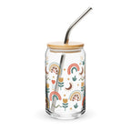 Glass tumbler with a bamboo lid and metal straw featuring colorful patterns on a white background.