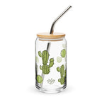 Clear glass tumbler with bamboo lid and metal straw featuring cactus designs on a white background