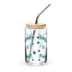 Clear glass tumbler with dragonfly design, wooden lid, and metal straw on a white background