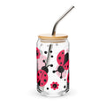 Clear tumbler with ladybug design, wooden lid, and metal straw on a white background