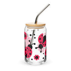 Clear tumbler with ladybug design, wooden lid, and metal straw on a white background