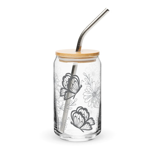 Clear glass tumbler with butterfly design, wooden lid, and metal straw on a white background