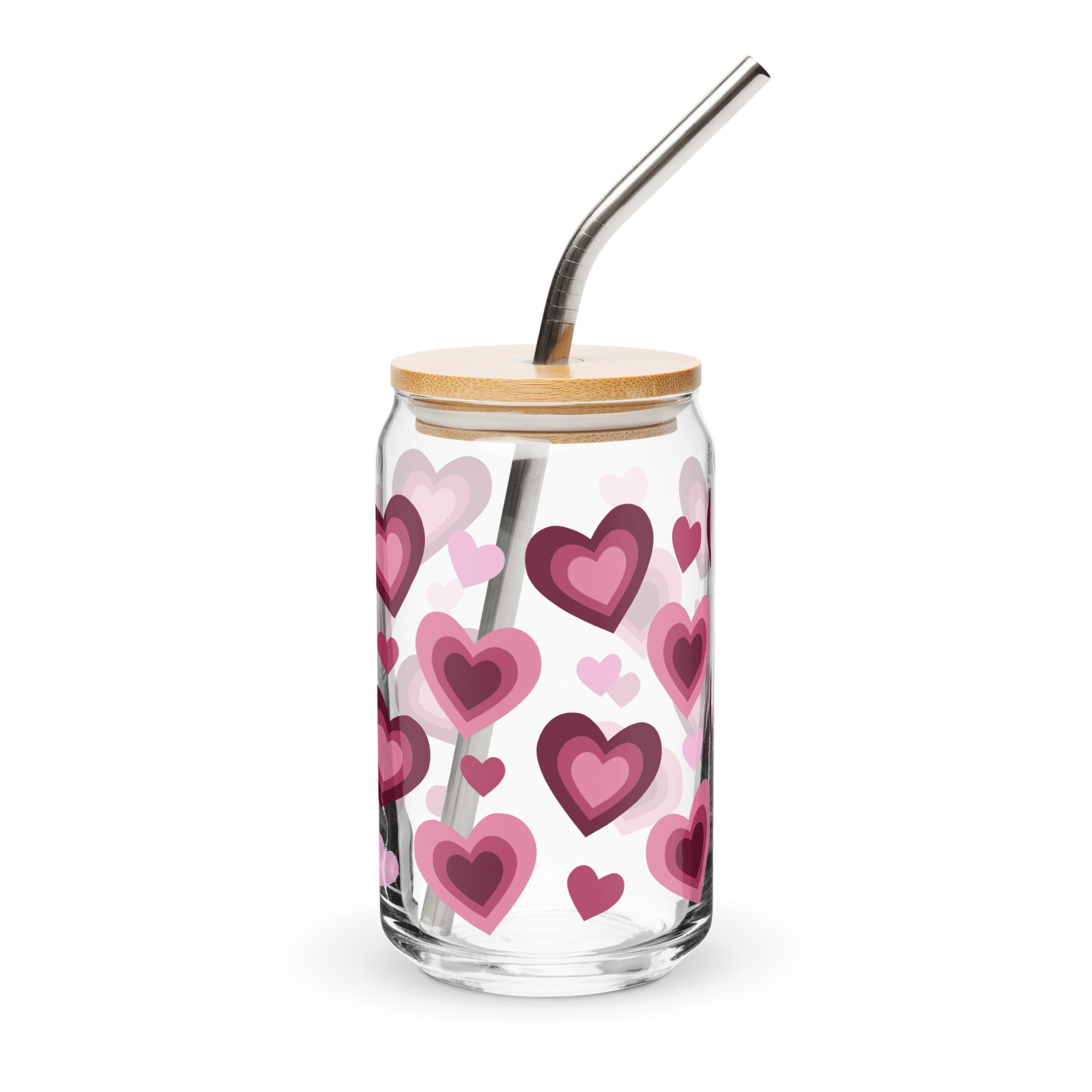 Glass tumbler with heart pattern, wooden lid, and metal straw on a white background