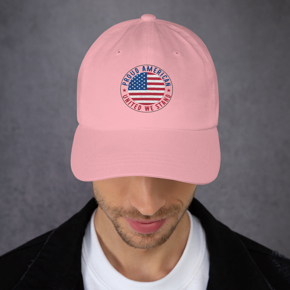 Person wearing a pink cap with embroidered Proud American United we Stand text and US flag graphic on a gray background