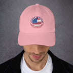 Person wearing a pink cap with embroidered Proud American United we Stand text and US flag graphic on a gray background