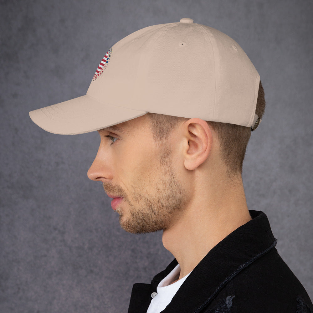 Man wearing a beige cap with a logo on a gray background