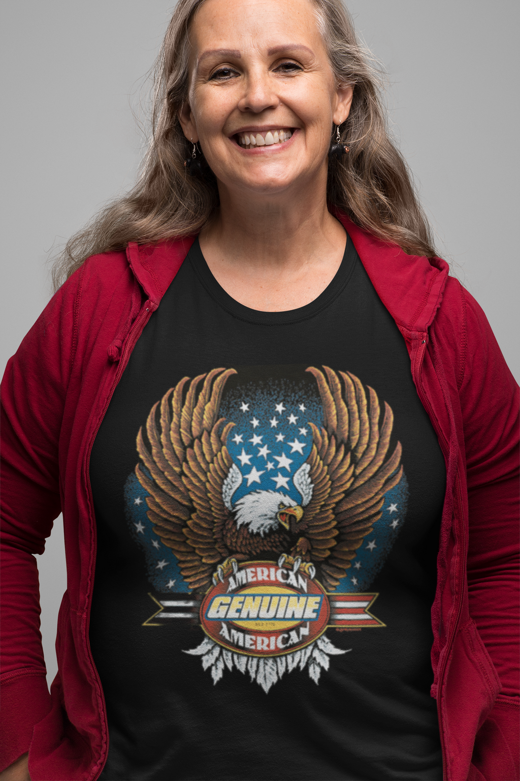 Person wearing a black t-shirt with an eagle and American flag design, smiling against a gray background