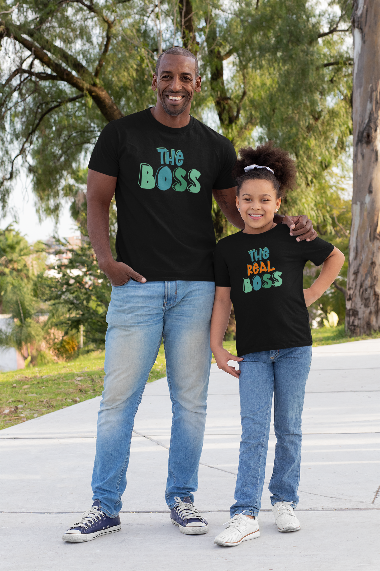 Dad and daughter wearing matching black t-shirts that say “The Boss” and “The Real Boss”