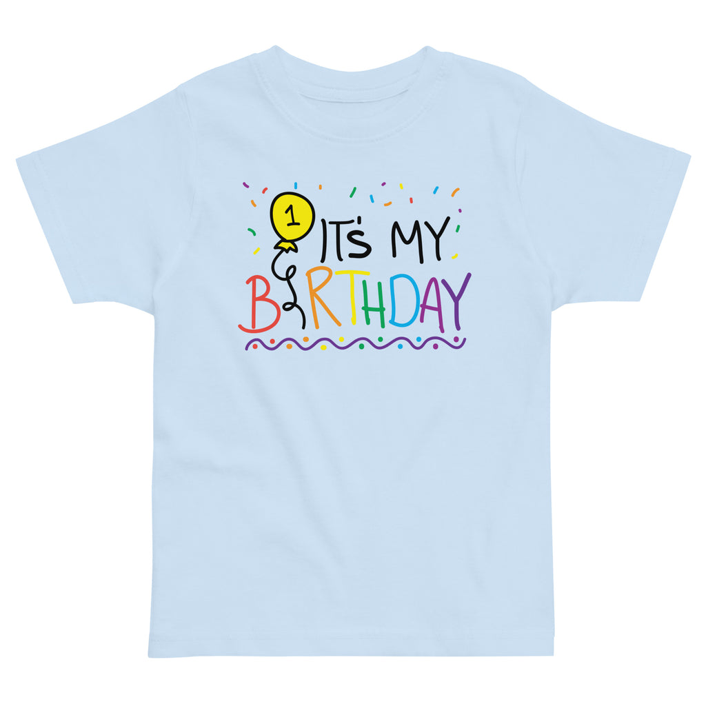 Light blue t-shirt with colorful 'It's My 1st Birthday' design on a white background