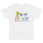 White t-shirt with colorful 'It's My 1st Birthday' text and balloon design on a white background