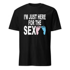 black unisex t-shirt with bold black text reading "I'm Just Here for the Sex" displayed flat-lay, styled for a gender reveal party theme with pink and blue accents in the background