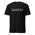 A black short-sleeve crewneck t-shirt featuring the word 'ZOMBIE' stylized in green camouflage letters, transitioning into 'BAE' in purple letters, displayed on a clean white background.