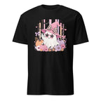 A black short-sleeve crewneck t-shirt featuring a colorful graphic print of a cute ghost character wearing a pink witch hat with a plaid bow, surrounded by flowers and pumpkins.